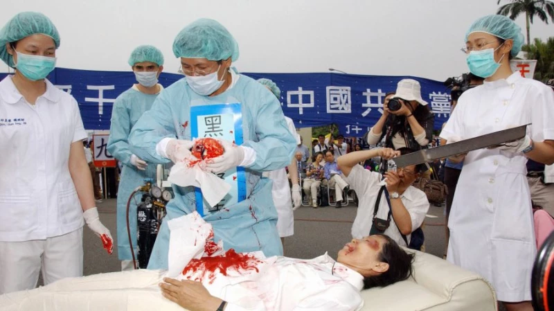 During a rally joined by thousands of Falun Gong practitioners at Taipei 23 April 2006, four demonstrators play in an action drama against what they said was the Chinese communists' killing of Falun Gong followers and harvesting of their organs in concentration camps. (Patrick Lin/AFP/Getty Images)